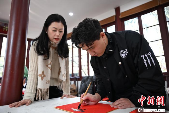 1月20日，外籍留學生在西泠印社社員李硯指導下寫福。當日，來自巴西、馬來西亞、加納、哈薩克斯坦的外籍留學生在浙江杭州西泠印社體驗福貼、春聯(lián)和篆刻，感受古老的中國傳統(tǒng)文化。中新社記者 王剛 攝