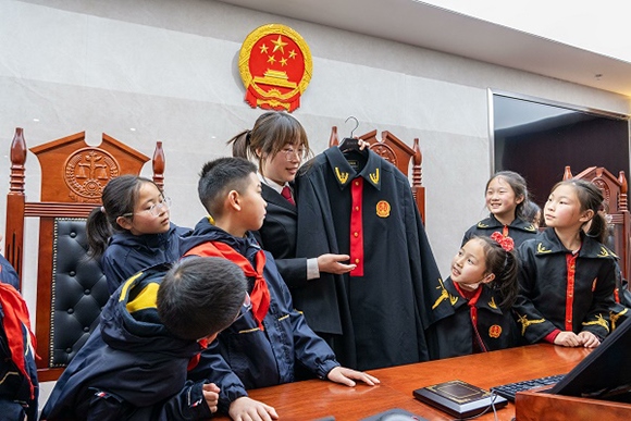 圖②：干警向同學(xué)們介紹法袍。