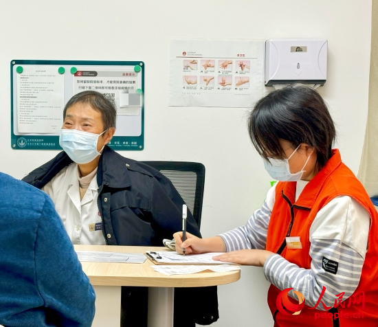 秦苑（中）接診患者。人民網(wǎng)記者 金慧慧攝