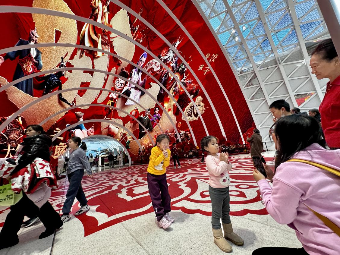 乙巳蛇年春節(jié)期間，影迷在《哪吒之魔童鬧?！肪薹?bào)前拍照打卡。