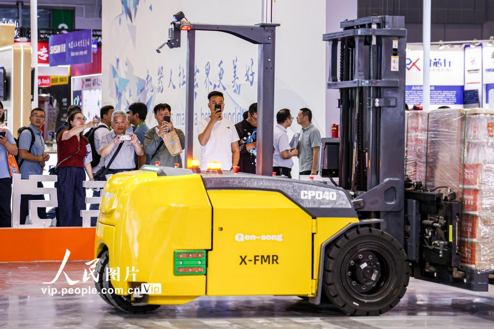 第24屆中國工博會(huì)現(xiàn)場，觀眾觀看叉取機(jī)器人作業(yè)演示。王初攝（人民圖片網(wǎng)）