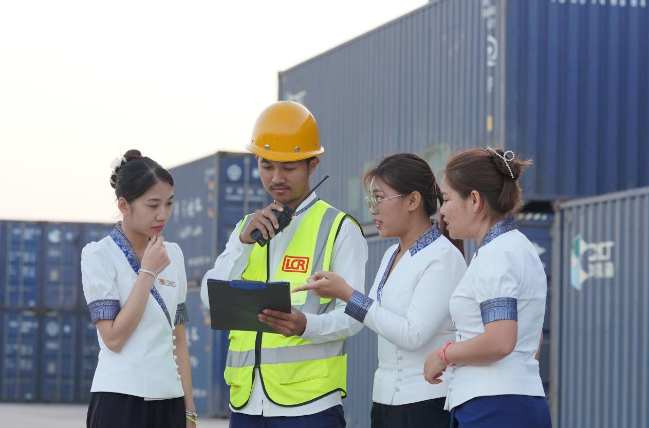 萬象南站貨運(yùn)值班員陳尼啦（左一）與同事在一起討論工作。老中鐵路有限公司供圖