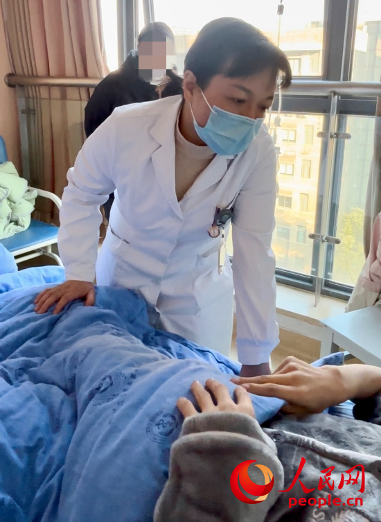 鄧茜查房時詢問患者情況。人民網(wǎng)記者 金慧慧攝