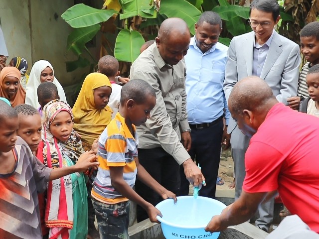 在日前舉行的安全供水工程揭牌儀式上，當(dāng)?shù)匦∨笥言诠┧c(diǎn)接水。 施亮攝