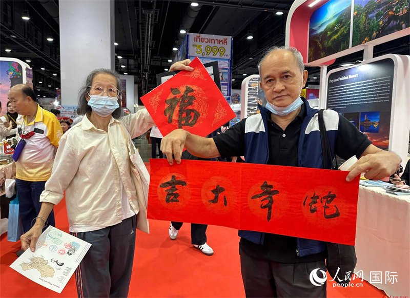 2025蛇年春節(jié)，泰國市民展示他們領(lǐng)到的華人手寫春聯(lián)。人民網(wǎng)記者 簡承淵攝