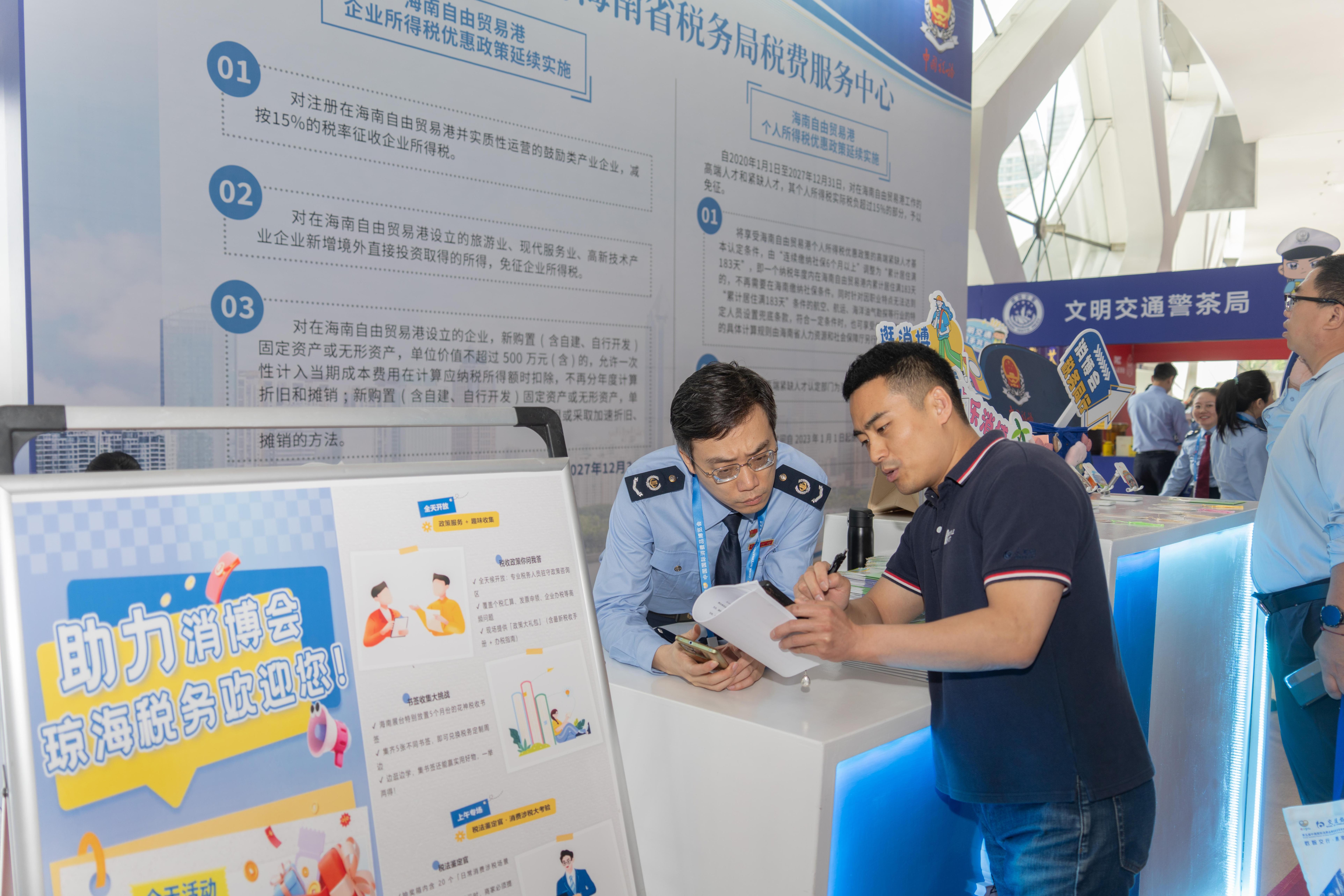 稅務(wù)服務(wù)臺(tái)工作人員向記者介紹服務(wù)參展外商的具體舉措。人民網(wǎng)記者 許崢攝