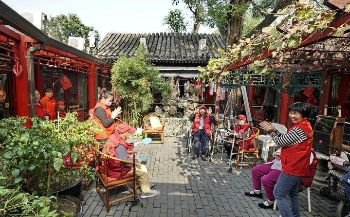 2024年10月12日，鐘樓灣胡同的老年人在社區(qū)內(nèi)的四合院養(yǎng)老驛站休閑。2017年起，北京市先后開展了兩輪背街小巷環(huán)境整治提升行動，完整保留了中軸線生活建筑群的歷史信息，并根據(jù)居民的生活和居住方式進行適配化的更新和改造，極大地改善了生活環(huán)境。2023年鐘樓灣胡同被評為“北京最美街巷”。