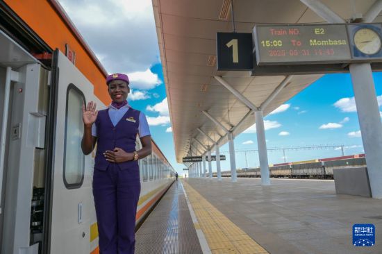 5月31日，在蒙內(nèi)鐵路內(nèi)羅畢站，一名乘務(wù)員在即將開往蒙巴薩的E2次列車旁等候乘客。新華社記者 楊光 攝