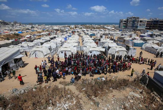 5月28日，人們在加沙城西部的沙提難民營等待領取救助食物。新華社發(fā)（里澤克·阿卜杜勒賈瓦德攝）