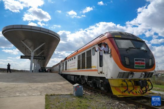 5月31日，在蒙內(nèi)鐵路內(nèi)羅畢站，機(jī)車駕駛員蔣立平（右）和博爾在即將開往蒙巴薩的E2次列車上揮手致意。新華社記者 楊光 攝