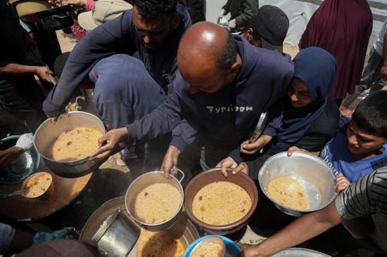 5月28日，人們在加沙城西部的沙提難民營領取救助食物。新華社發(fā)（里澤克·阿卜杜勒賈瓦德攝）