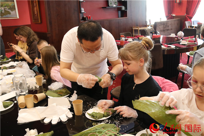 烏克蘭兒童學(xué)習(xí)體驗包粽子。人民網(wǎng)記者蔡子暢攝
